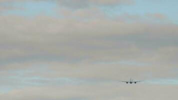 Long shot of a jet passenger plane taking off, climbing in a cloudy sky. Aircraft departure video