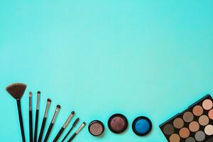 Various cosmetics and brushes on blue background photo