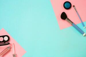 Make up essentials. Set of professional make up brushes, creams and shadows in jars on blue background. photo