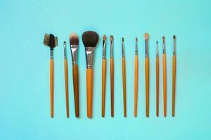 Make up essentials. Set of professional make up brushes on blue background. photo