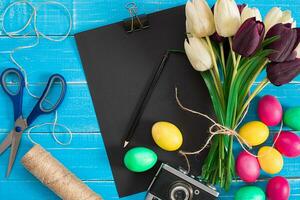 Easter eggs and tulips on blue rustic wooden planks photo