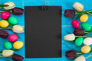 Easter eggs and tulips on blue wooden planks photo