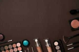 Make up essentials. Set of professional make up brushes, creams and shadows in jars on dark background. photo