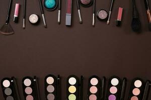 Make up essentials. Set of professional make up brushes, creams and shadows in jars on dark background. photo