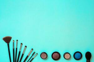 Various cosmetics and brushes on blue background photo