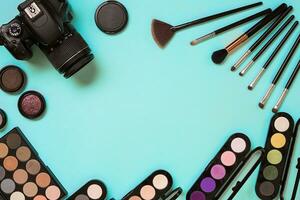 Make up essentials. Set of professional make up brushes, creams and shadows in jars on blue background. photo