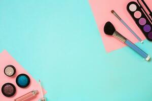 Make up essentials. Set of professional make up brushes, creams and shadows in jars on blue background. photo