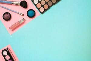 Make up essentials. Set of professional make up brushes, creams and shadows in jars on blue background. photo