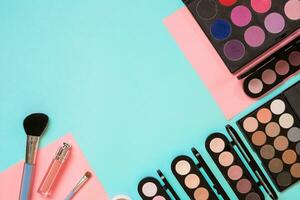 Make up essentials. Set of professional make up brushes, creams and shadows in jars on blue background. photo