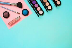 Various cosmetics and brushes on blue background photo