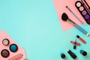 Make up essentials. Set of professional make up brushes, creams and shadows in jars on blue background. photo