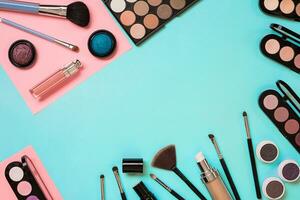 Make up essentials. Set of professional make up brushes, creams and shadows in jars on blue background. photo