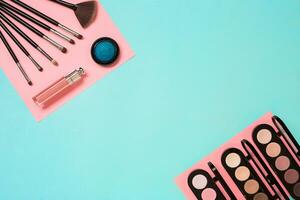 Make up essentials. Set of professional make up brushes, creams and shadows in jars on blue background. photo