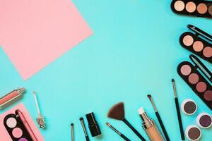 Various cosmetics and brushes on blue background photo