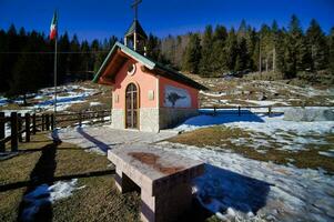 a small chapel in the middle of a snowy field photo