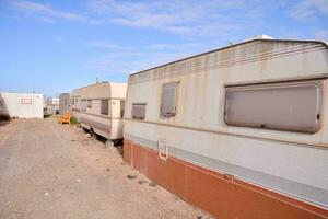 a row of rv's parked in a gravel lot photo