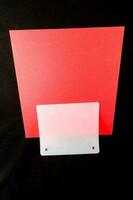 a red card with a white card holder on it photo