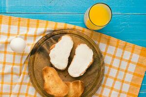 Top view of toast bread and toast butter served with juice on wooden table. photo