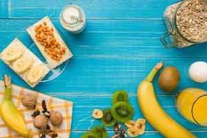 Bowl of fresh oatmeal porridge with kiwi and nuts on teal rustic table photo