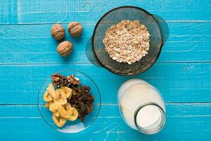 Porridge, oats, milk and banana on the table photo