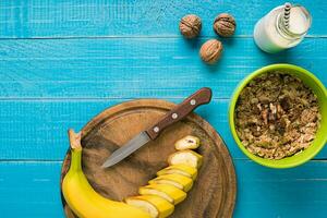 healthy breakfast with bowl of homemade oatmeal with fruits and milk over rustic wooden background. photo