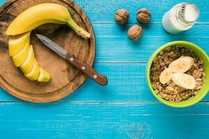 sano desayuno con cuenco de hecho en casa harina de avena con frutas y Leche terminado rústico de madera antecedentes. foto