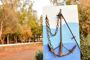 an anchor on a sign in front of trees photo