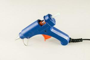 a blue and orange glue gun on a white surface photo