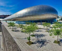 the building is made of metal and has a large curved shape photo
