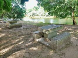 two concrete benches sit next to a river photo