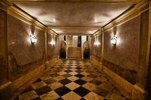 the hallway is decorated with a checkered floor and a staircase photo