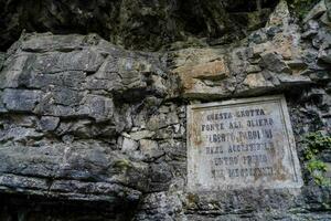 a plaque on the side of a rock wall photo