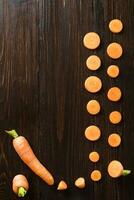 rebanado Zanahoria en pizarra y de madera mostrador parte superior antecedentes foto