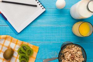 Breakfast table with granola, milk, fruits and juice. Top view. Space for text. photo