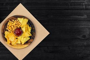 Wide selection of snacks for beer with different sauces on parchment top view photo