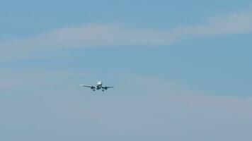 Jet plane approaching landing in the blue sky, view from below. Passenger flight arrival video