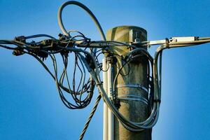 a close up of a telephone pole with wires attached photo