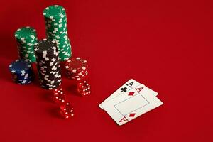 Poker chips and aces on red background. Group of different poker chips. Casino background. photo