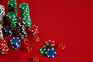 Poker chips on red background. Group of different poker chips. Casino background. photo