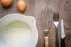 Food ingredients and kitchen utensils for cooking on wooden background photo