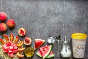 Ingredients for oatmeal on dark wooden table. Concept of healthy food. Top view, copy space. photo