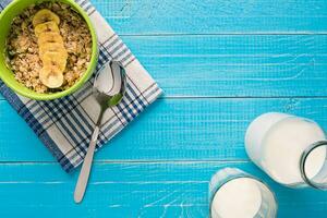Porridge, oats, milk and banana on the table photo