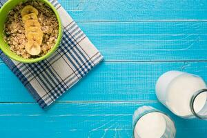 Porridge, oats, milk and banana on the table photo