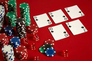 Casino gambling poker equipment and entertainment concept - close up of playing cards and chips at red background. Straight Flush photo