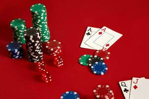 Poker chips and aces on red background. Group of different poker chips. Casino background. photo