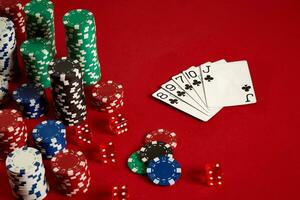 Casino gambling poker equipment and entertainment concept - close up of playing cards and chips at red background. Straight Flush photo