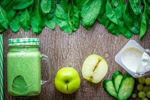 verde zalamero con manzanas, yogur, espinaca, Pepino en de madera antecedentes foto