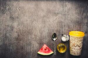 Ingredients for oatmeal on dark wooden table. Concept of healthy food. Top view, copy space. Toned photo