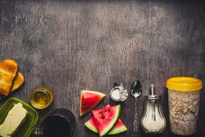 Healthy breakfast ingredients. Bowl of oat granola, fresh fruit and honey. Top view, copy space. Toned photo