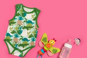 Baby clothes and accessories on pink background. Top view photo